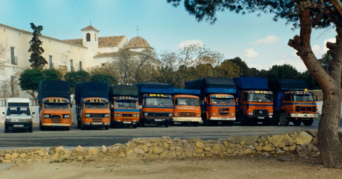 Imagen de una fila de camiones vistos de frente delante de un santuario
