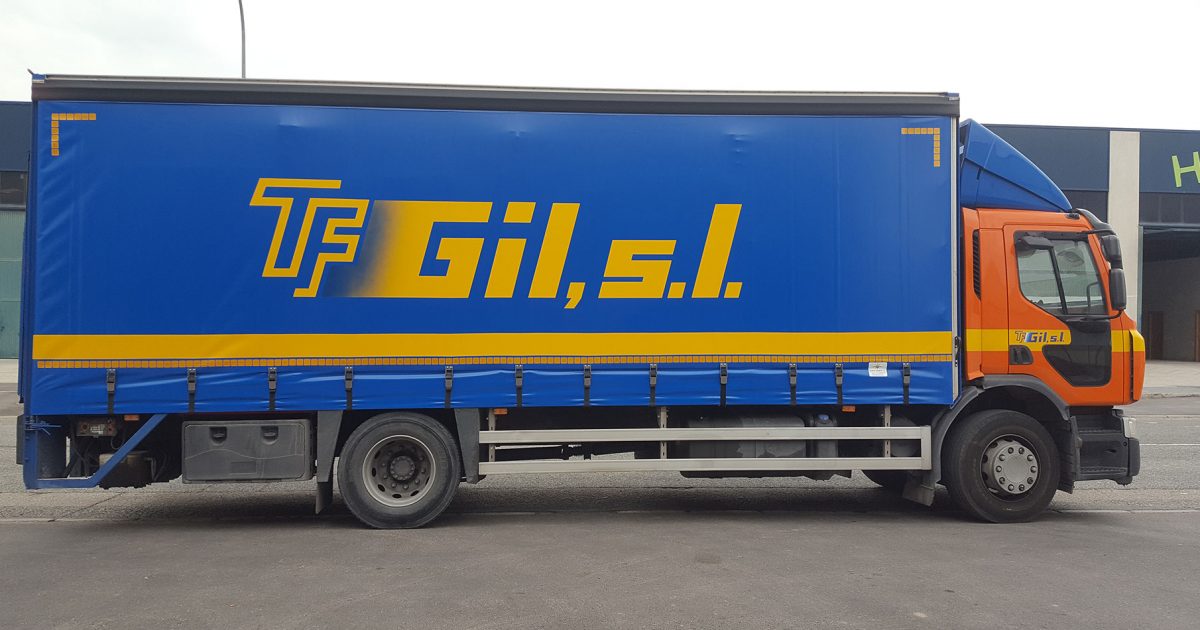 Camión mediano de transporte de mercancías aparcado en la puerta de una nave