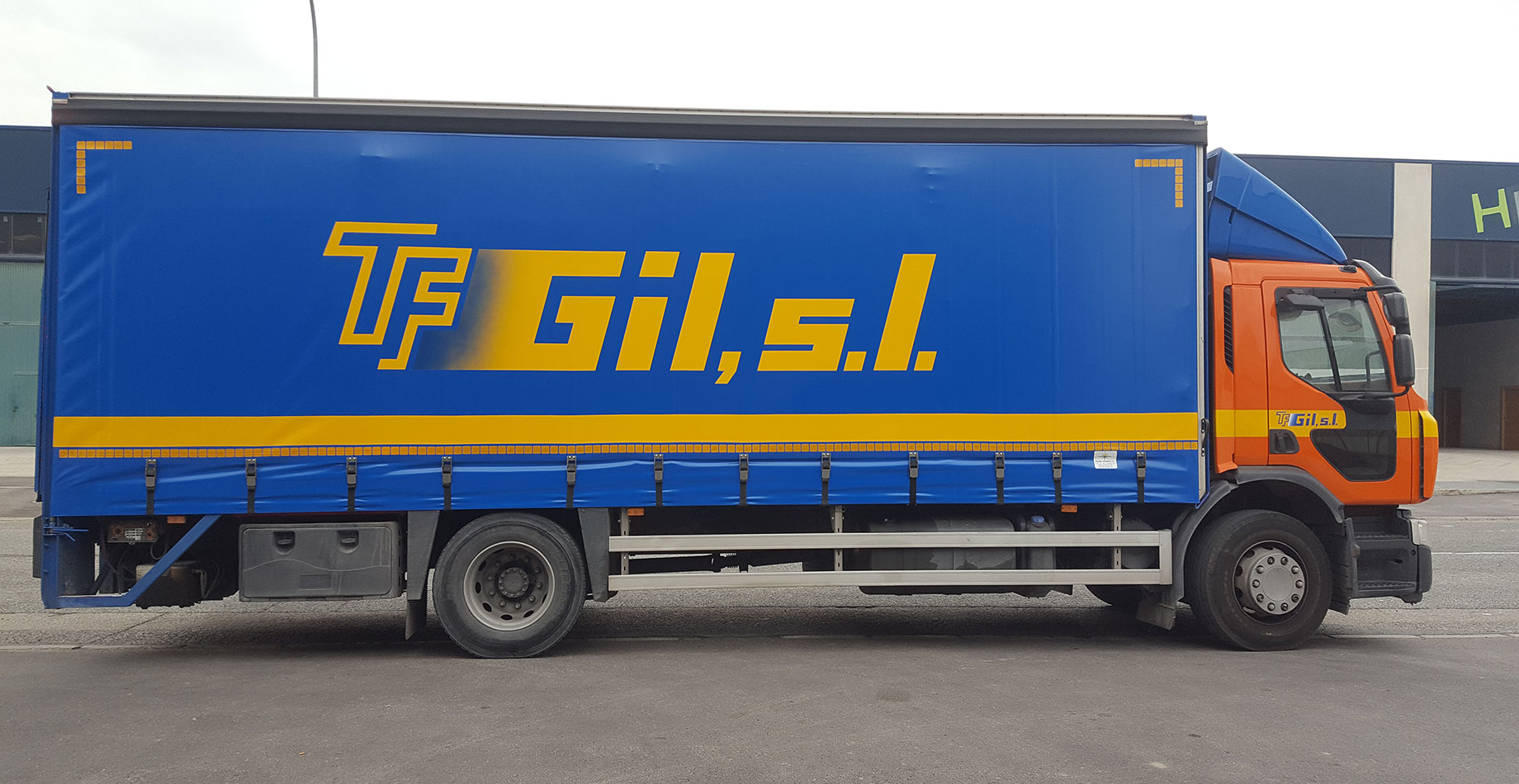 Camión mediano de transporte de mercancías aparcado en la puerta de una nave