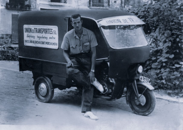 Foto en blanco y negro de un hombre sentado en un motocarro de transportes