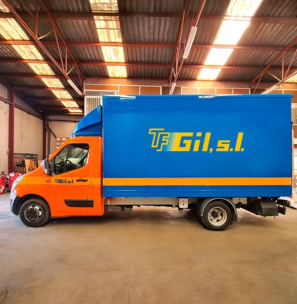 Camión pequeño de transporte de mercancías aparcado dentro de una nave