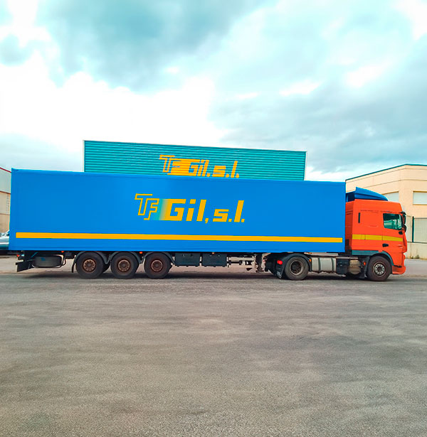 Trailer de transporte de mercancías aparcado delante de una nave