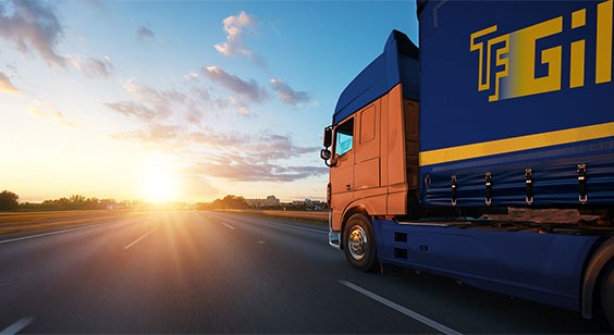 Camión de transporte de mercancías circulando por una carretera al atardecer