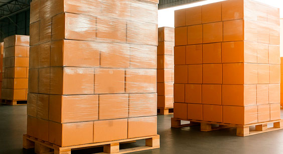 Varios palets llenos de paquetes y envueltos en film plástico transparente